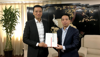 太古（中国）有限公司主席朱国梁（左）向国务院港澳事务办公室副主任黄柳权（右）赠书《太古之道》并合影。