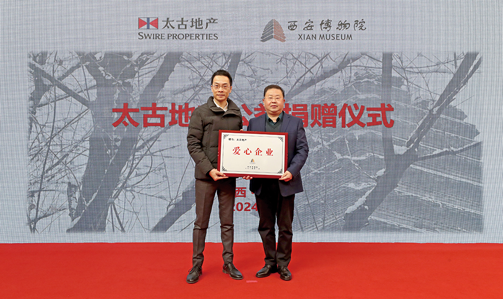 西安博物院党委书记甘洪更（右）向太古地产西安总经理李志豪（左）授予爱心企业奖牌。